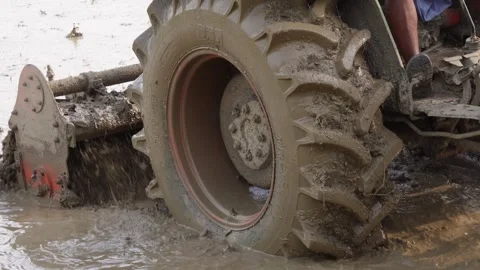 A close up of a tractor tire in a muddy field Stock Footage 314573845