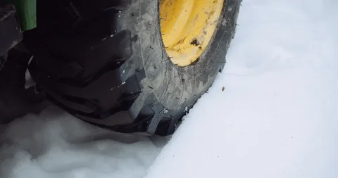 Close up of tractor tire slowly rolling in freshly fallen snow Stock Footage 122041121