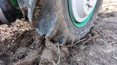 Close-up of a tractor tire spinning and gaining traction in muddy forest ground Stock Footage 333642840