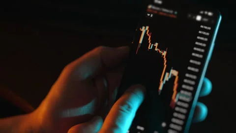 Close up of trader analyzing candlestick chart on smartphone. Stockbeeldmateriaal 330216643