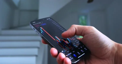 Close up trader investor broker using mobile phone app analyzing financial data Stock Footage 230121084