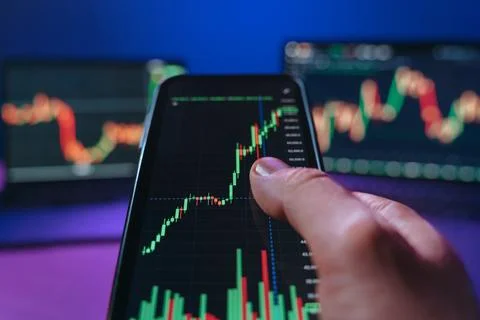 Close-up of trader using trading app on smartphone Stock Photos