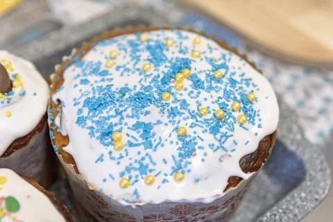 A close-up of a traditional Easter bread Paska topped with white icing, blue Stock Photos