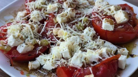 Close-up of a traditional Greek dish featuring sliced tomatoes topped with cubes Stock Footage 346665890