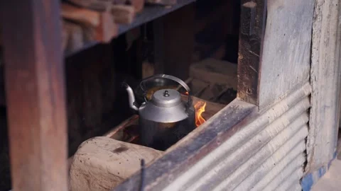 Close up of a traditional metal kettle boiling over an open wood fire inside a Stock Footage 343676961