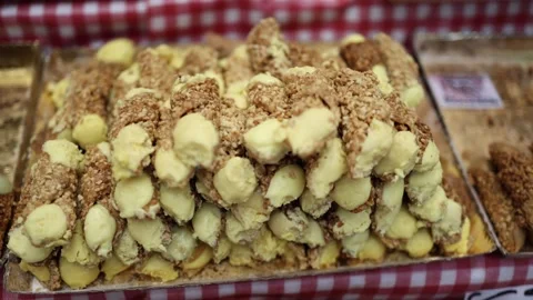 Close-up of traditional nut-covered pastry rolls filled with creamy yellow custa Stock Footage 289218101