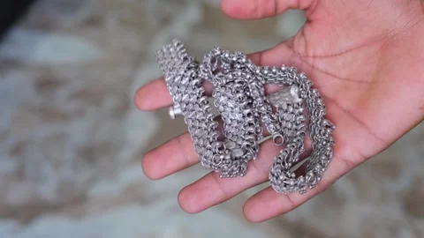 Close-up of traditional silver anklets in hand Stockbeeldmateriaal 330661160