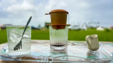 Close Up of Traditional Vietnamese Phin Filter Brewing Iced Coffee on Tray in Stock Footage 345951544