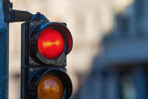 Close-up of traffic semaphore with red light on defocused city street backgro Stock Photos