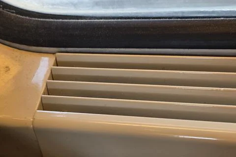 Close-Up of Train Window Frame and Heater Vent on Vintage Rail Journey 写真素材