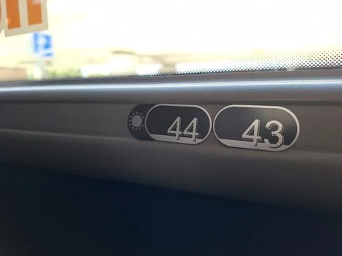 Close-up of train window seat numbers 44 and 43 in daylight Stock Photos