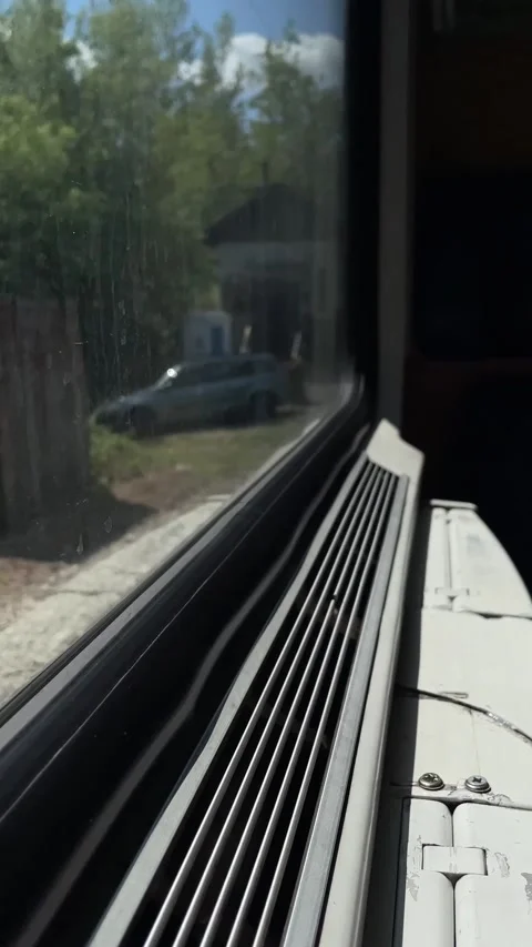 Close-up train window sill and vent with passing rural landscape and D Stock Footage 347323635