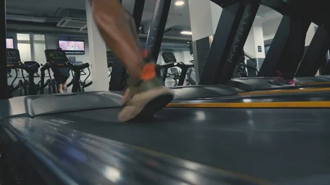 Close up of trainers running on a treadmill in slow motion in the gym Stock Footage 89577320