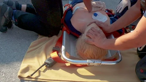 Close up on training mannequin as firefighter practices cpr, providing Stock Footage 96676349