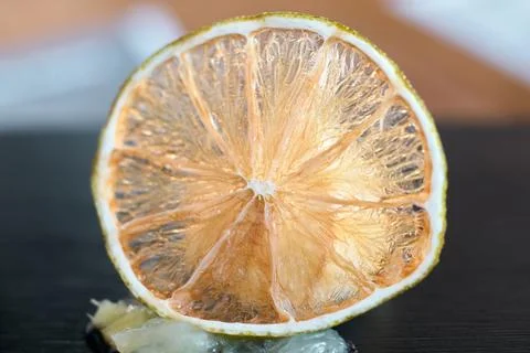 Close-up of a translucent dried lime slice standing on a dark surface Stock Photos