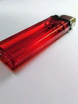 Close-up of a translucent red disposable lighter with a brass-colored metal.. Stock Photos