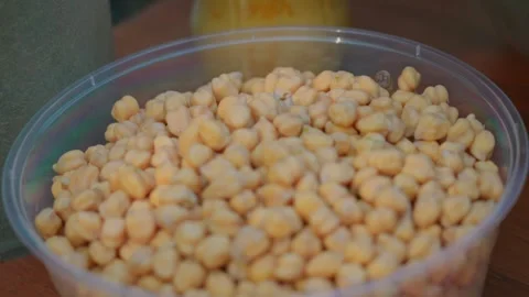 Close-up of transparent container with dry chickpeas for Uzbek plov Stock Footage 332151115