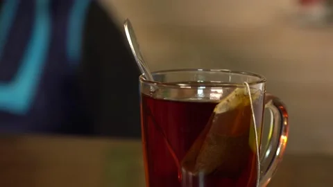 Close-up. transparent cup with tea bag. making tea from a disposable tea bag Video stock 144395420