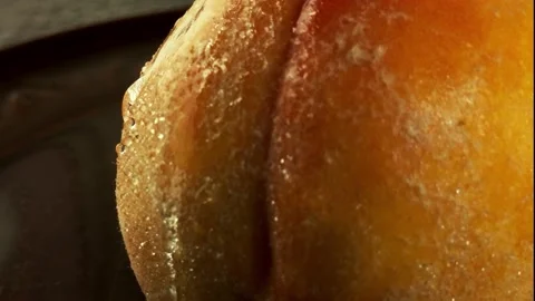 Close-up transparent drops flow from a ripe juicy peach Video stock 205174228