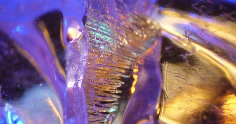 Close-up of transparent ice cubes with air bubbles shimmering in bright colors Stock Footage 239657594