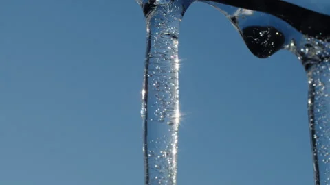 Close-up of transparent icicle with trapped air bubbles and sunlight reflections Stock Footage 303666029