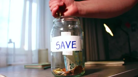 Close up of transparent money jar. Represents traditional saving methods and Vídeos de archivo 330588753