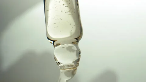 Close-up of a transparent pipette from which liquid is squeezed out in drops Vidéo 292438965