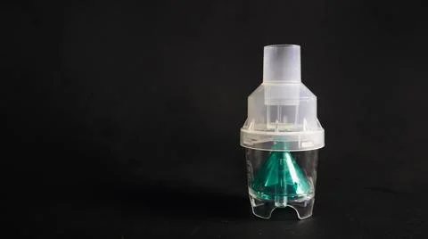 A close-up of a transparent plastic nebulizer cup with a green internal com.. Stock Photos