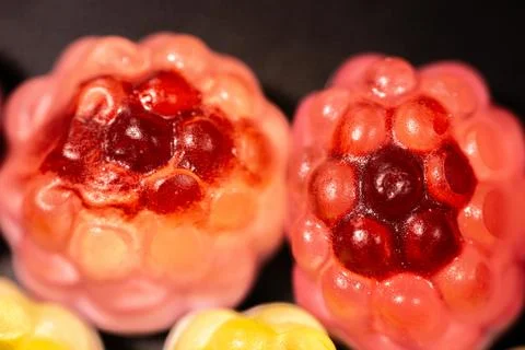 A close-up of transparent raspberry-shaped gummy candies with a shiny. 스톡 사진
