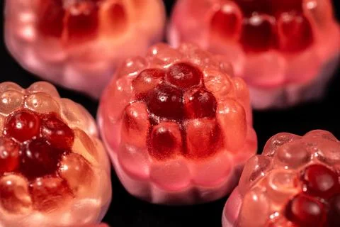 A close-up of transparent raspberry-shaped gummy candies with a shiny. Stock Photos