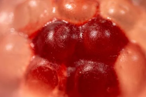 A close-up of transparent raspberry-shaped gummy candies with a shiny. Stock Photos