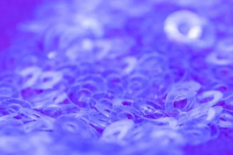 Close-up of transparent sequins on blue fabric II Stock Photos