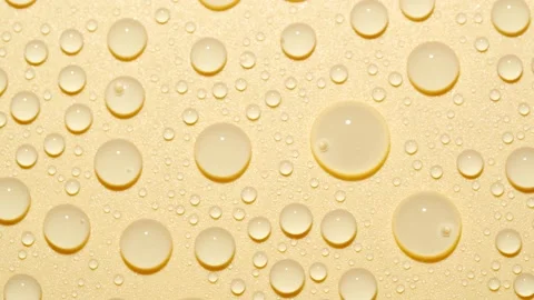 Close-up transparent water drops texture rotating on golden abstract background Stock Footage 178320373