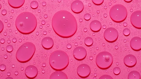 Close-up transparent water drops texture rotating on pink abstract background Video stock 182754958