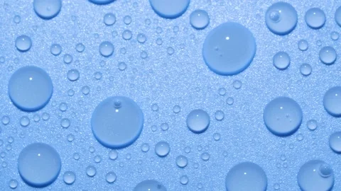 Close-up transparent water drops texture rotating on blue chroma key background Stock Footage 186421847