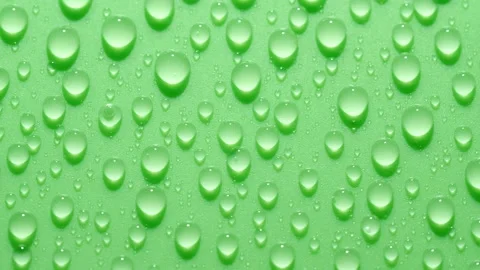 Close-up transparent water drops texture rotating on green chroma key background Stock Footage 187425463