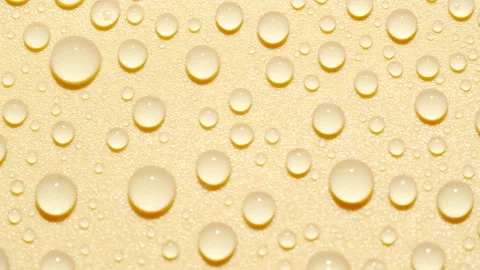 Close-up transparent water drops texture rotating on golden abstract background Stock Footage 189728161