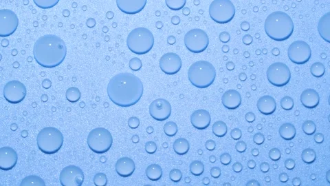 Close-up transparent water drops texture rotating on blue chroma key background Stock Footage 190858188
