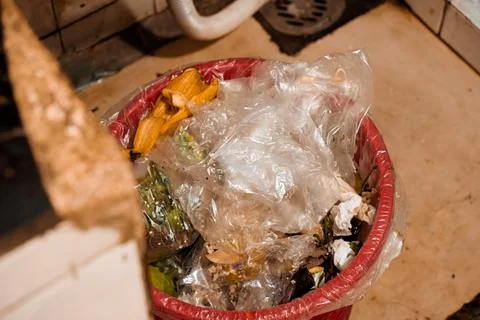 A close-up of a trash bin filled with plastic and organic waste Stock Photos