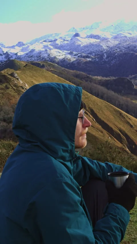 Close-up traveler drinking tea with snowy mountains behind. Video stock 337652055
