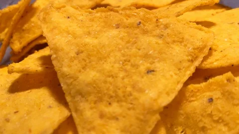 Close up. Triangle nachos corn chips slowly rotating. Unhealthy Video stock 120609694