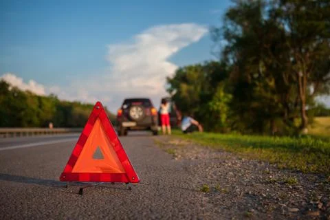 Close-up Of A Triangular Warning Sign With Couple Standing In Front Of Broken Stock Photos
