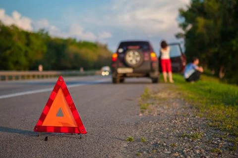 Close-up Of A Triangular Warning Sign With Couple Standing In Front Of Broken Stock Photos