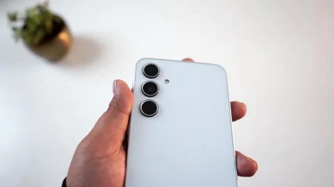 Close-up of the triple camera lens module of Samsung Galaxy A35 smartphone Stock Footage 327194350