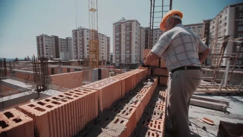 Close up trough the wall to a builder who place a bricks Stock Footage 143562879