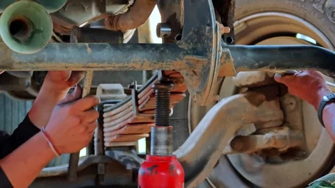 Close up of truck maintenance hands working on suspension system with tools and 動画素材 342710488