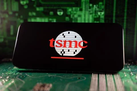 Close up of TSMC logo on smartphone screen with motherboard background. Toronto, Stock Photos