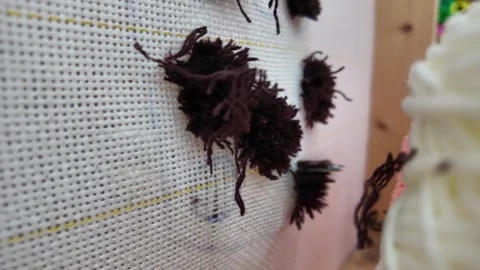 Close-up of a tufting gun creating a colorful rug Stock Footage 342272435