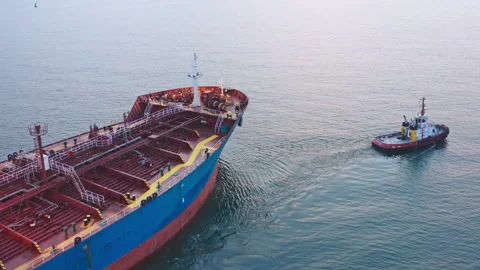 Close up Tugboat drag cargo ship near sea port aerial view. Maritime navigation Stock Footage 238008513
