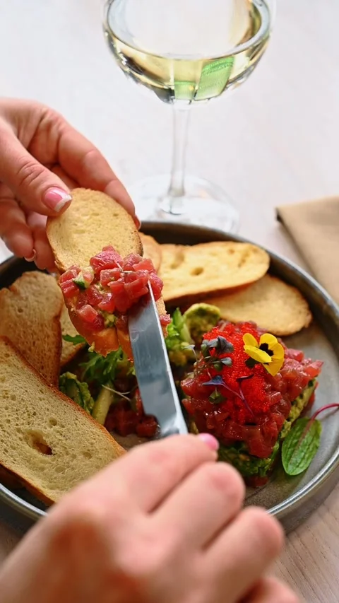 Close up of tuna tartare on bread slice. Hand holding a slice of toasted bread Stock Footage 329511407